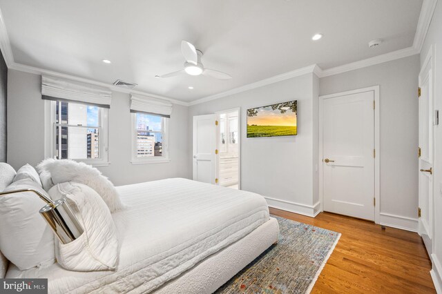 bedroom featuring ceiling fan, light hardwood / wood-style floors, crown molding, and ensuite bathroom