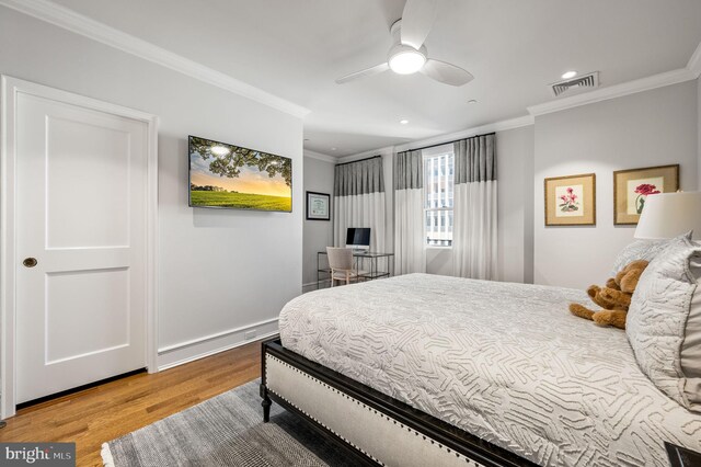 bedroom with light wood-type flooring, ceiling fan, and ornamental molding