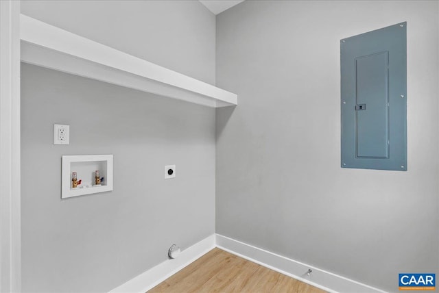 clothes washing area with wood-type flooring, hookup for a washing machine, electric panel, and electric dryer hookup