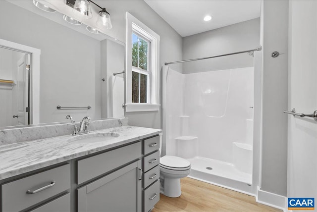 bathroom featuring vanity, toilet, a shower, and wood-type flooring