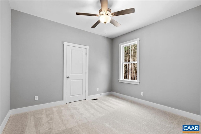 empty room with light colored carpet and ceiling fan