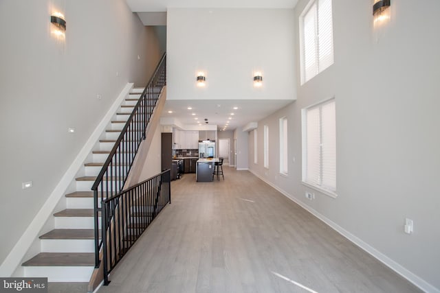 stairway featuring a high ceiling and hardwood / wood-style floors