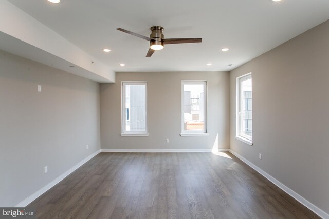 unfurnished room with ceiling fan, a wealth of natural light, and wood-type flooring