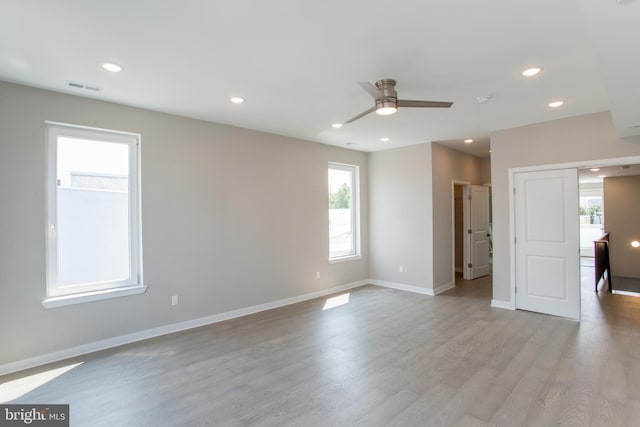 empty room with ceiling fan and light hardwood / wood-style floors