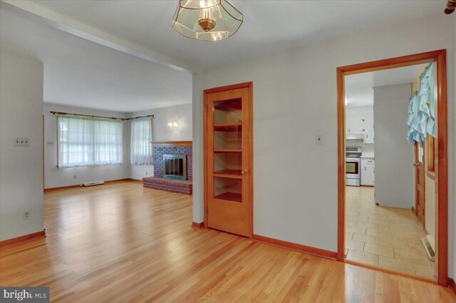 unfurnished living room with light tile patterned flooring and a brick fireplace