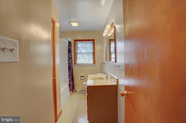 full bathroom with vanity, shower / tub combo with curtain, and toilet