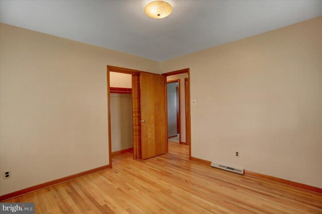 unfurnished bedroom featuring light hardwood / wood-style flooring and a closet