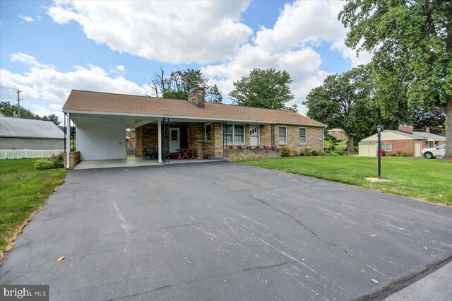 ranch-style home featuring a carport and a front yard