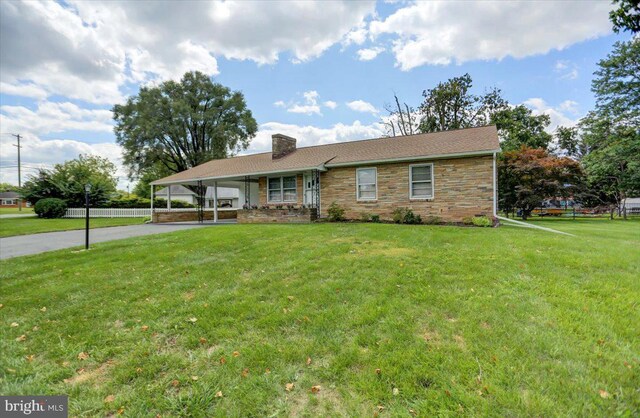 view of front facade with a front lawn and a carport