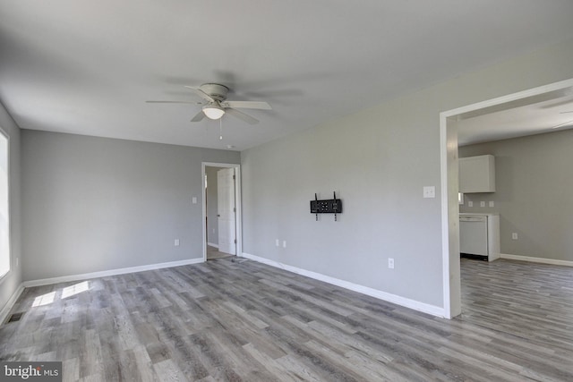 empty room with ceiling fan and light hardwood / wood-style floors