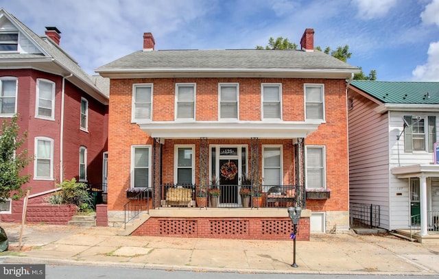 view of front facade featuring a chimney and brick siding