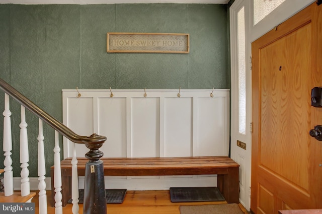 mudroom with a wainscoted wall and a decorative wall