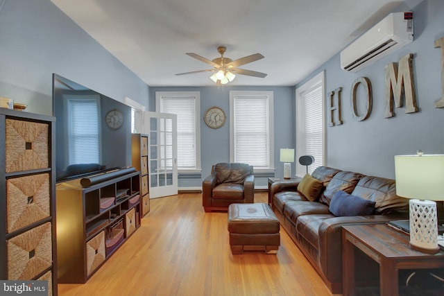 living room with light wood finished floors, a ceiling fan, and a wall mounted AC