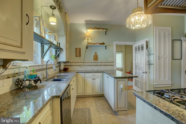 kitchen with appliances with stainless steel finishes, decorative light fixtures, a sink, and light stone counters