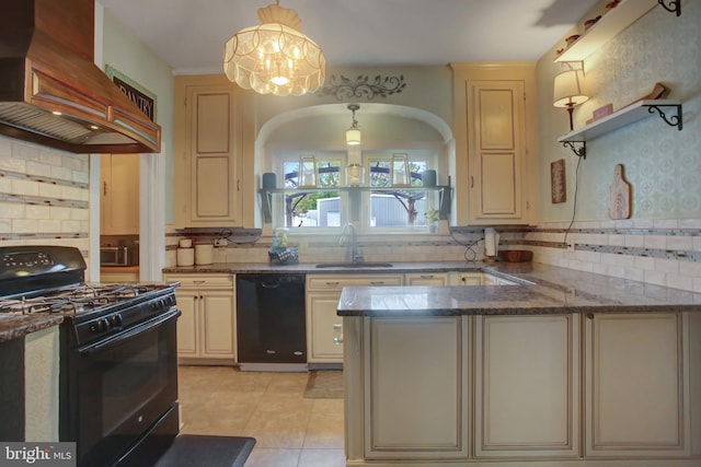 kitchen featuring hanging light fixtures, cream cabinets, black appliances, premium range hood, and a sink