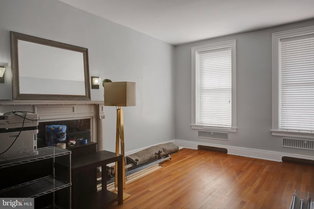 office area featuring baseboards, visible vents, and wood finished floors