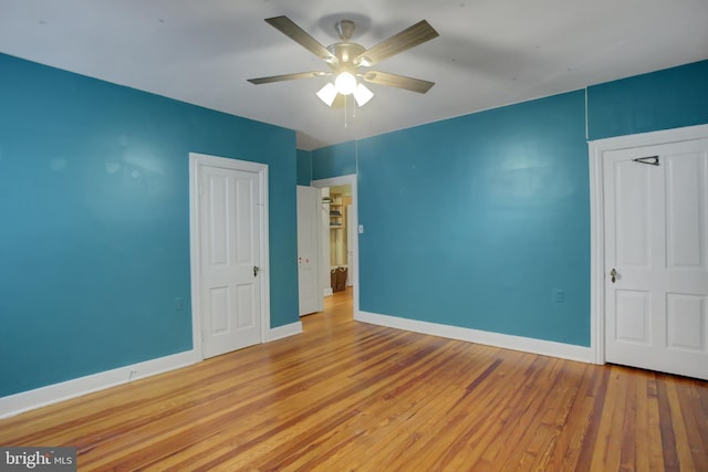 unfurnished bedroom with light wood-type flooring, ceiling fan, and baseboards