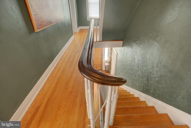 stairs featuring wood finished floors and baseboards