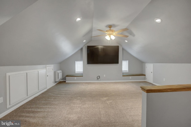 additional living space featuring vaulted ceiling, baseboards, a wealth of natural light, and light colored carpet