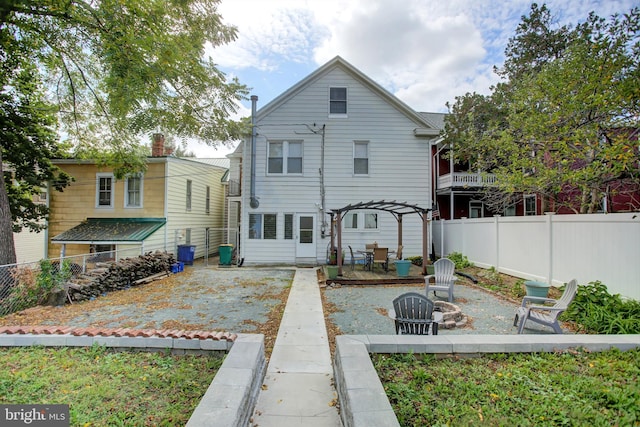 rear view of house featuring a patio, an outdoor fire pit, and a fenced backyard