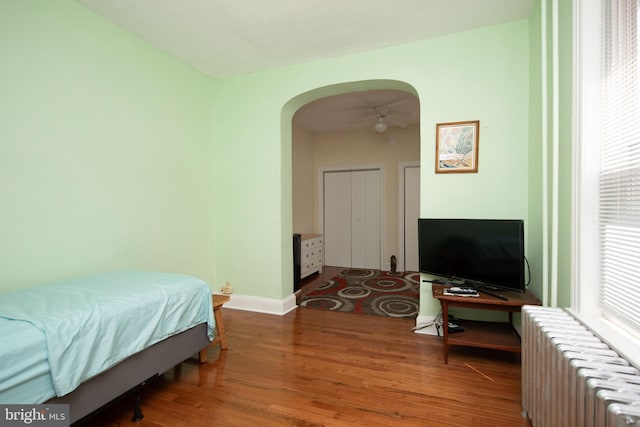 bedroom featuring hardwood / wood-style flooring and radiator heating unit