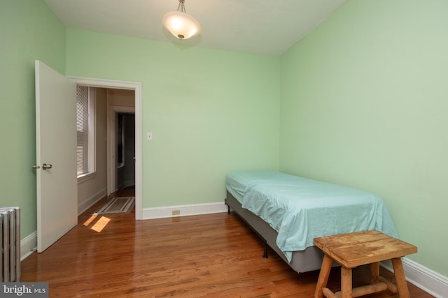 bedroom featuring wood-type flooring and radiator