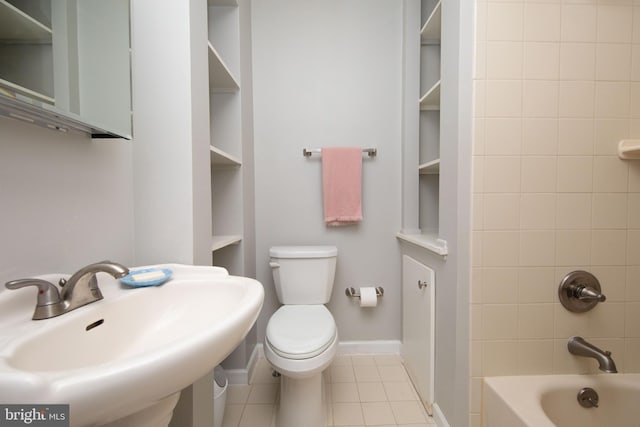 full bathroom with tile patterned flooring, tiled shower / bath, built in shelves, and toilet