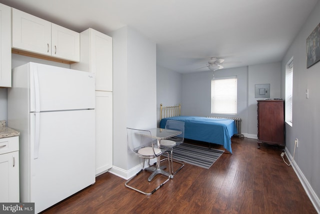 bedroom with ceiling fan, dark hardwood / wood-style floors, and white refrigerator