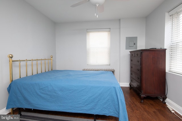 bedroom with ceiling fan, dark hardwood / wood-style floors, and electric panel