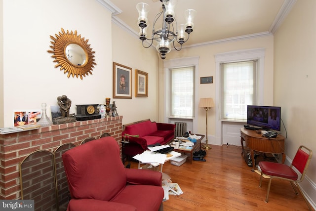 living room featuring radiator, a chandelier, ornamental molding, and hardwood / wood-style flooring