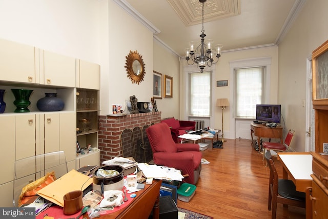 living room with a notable chandelier, light hardwood / wood-style flooring, radiator, and ornamental molding