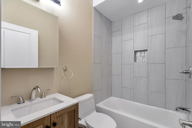 full bathroom with vanity, tiled shower / bath combo, and toilet