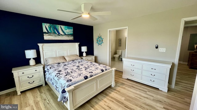 bedroom with light wood-type flooring, ceiling fan, and connected bathroom