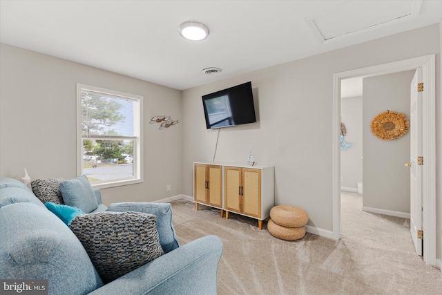 living room with visible vents, baseboards, carpet, and attic access