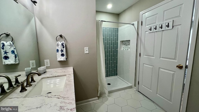 bathroom with tile patterned flooring, walk in shower, and vanity