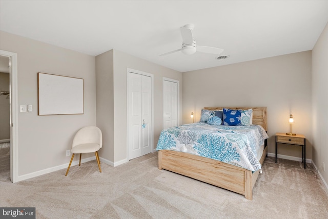 bedroom featuring ceiling fan, baseboards, multiple closets, and carpet floors