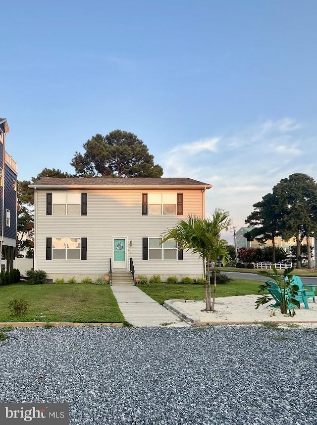 rear view of house featuring a lawn