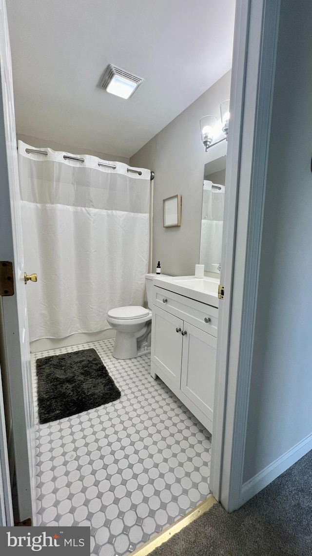 bathroom featuring a shower with shower curtain, toilet, and vanity