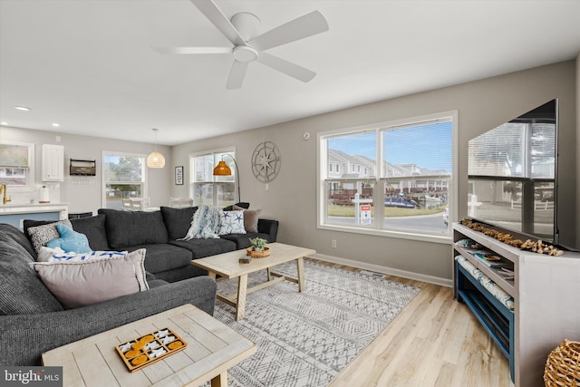 living area featuring recessed lighting, baseboards, light wood finished floors, and ceiling fan