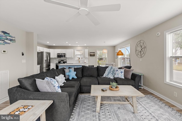 living area featuring light wood-type flooring, visible vents, a ceiling fan, recessed lighting, and baseboards