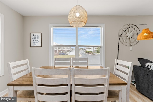 dining area featuring baseboards and light wood-style flooring