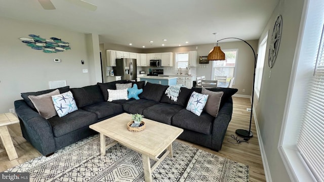 living room featuring ceiling fan and light wood-type flooring