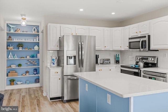 kitchen with light wood-type flooring, backsplash, white cabinetry, stainless steel appliances, and light countertops