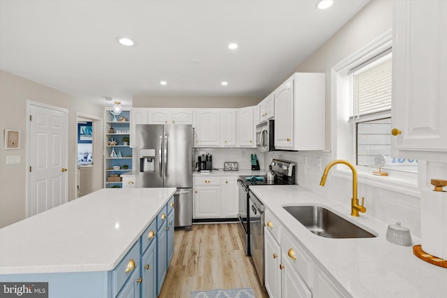 kitchen featuring stainless steel appliances, light hardwood / wood-style floors, white cabinetry, sink, and decorative backsplash