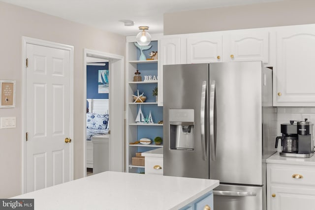 kitchen featuring open shelves, light countertops, stainless steel refrigerator with ice dispenser, and white cabinetry