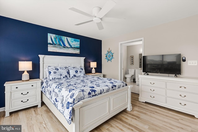 bedroom featuring light hardwood / wood-style floors, ceiling fan, and ensuite bathroom