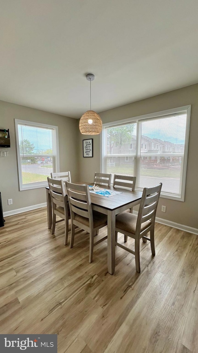 dining area featuring light wood-type flooring and a healthy amount of sunlight