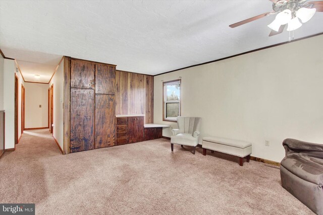 living area featuring ceiling fan, a textured ceiling, and light carpet