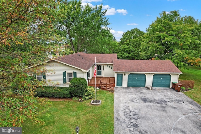 view of front of property with a wooden deck, a front yard, and a garage