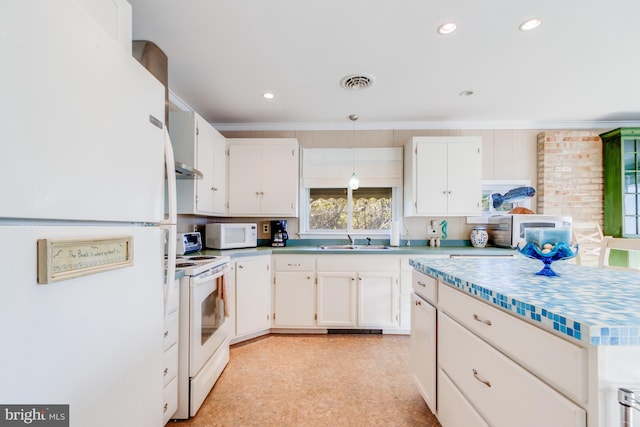 kitchen with brick wall, tasteful backsplash, white cabinetry, sink, and white appliances